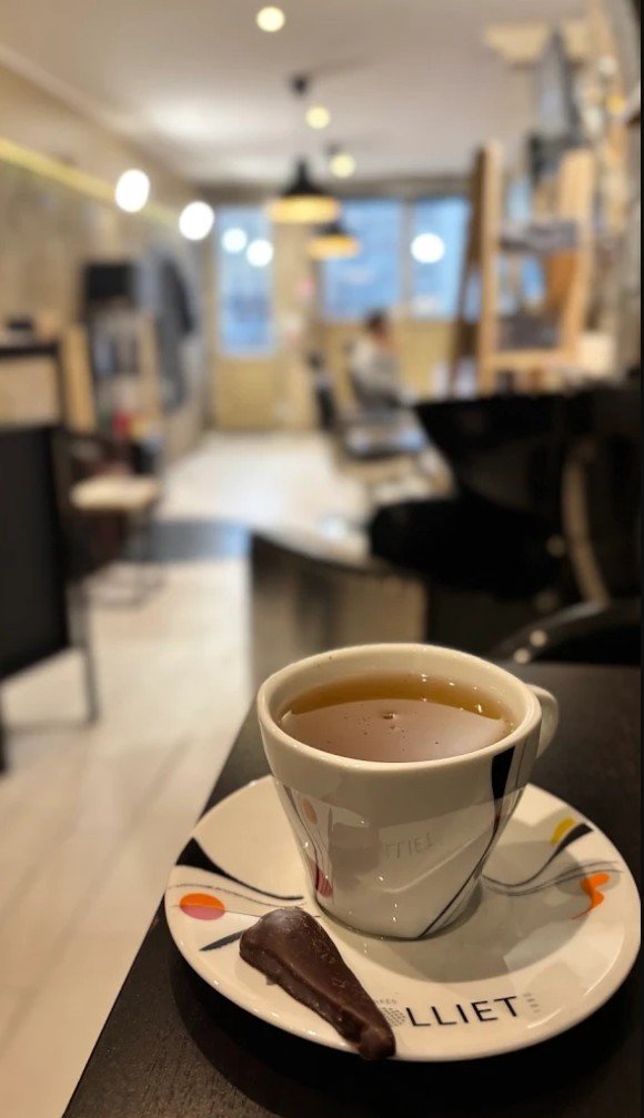 Une tasse de thé et un carré de chocolat servis au salon