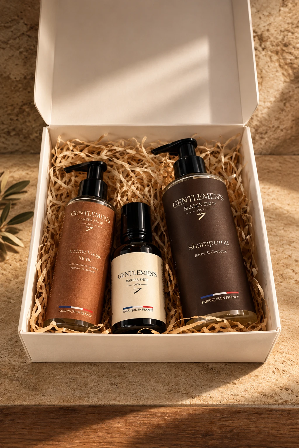 Le coffret Gentlemen’s ouvert : shampoing, crème visage et huile à barbe sur un lit de frisure kraft