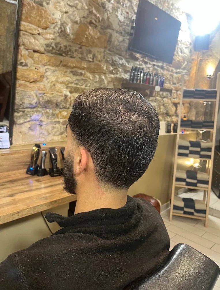 Un dégradé net et une barbe taillée, vus de dos